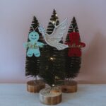 Red and green gingerbread man with glitter name and dove ornaments on Christmas trees