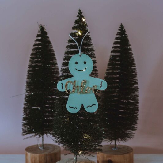 Green gingerbread man with glitter name on Christmas tree